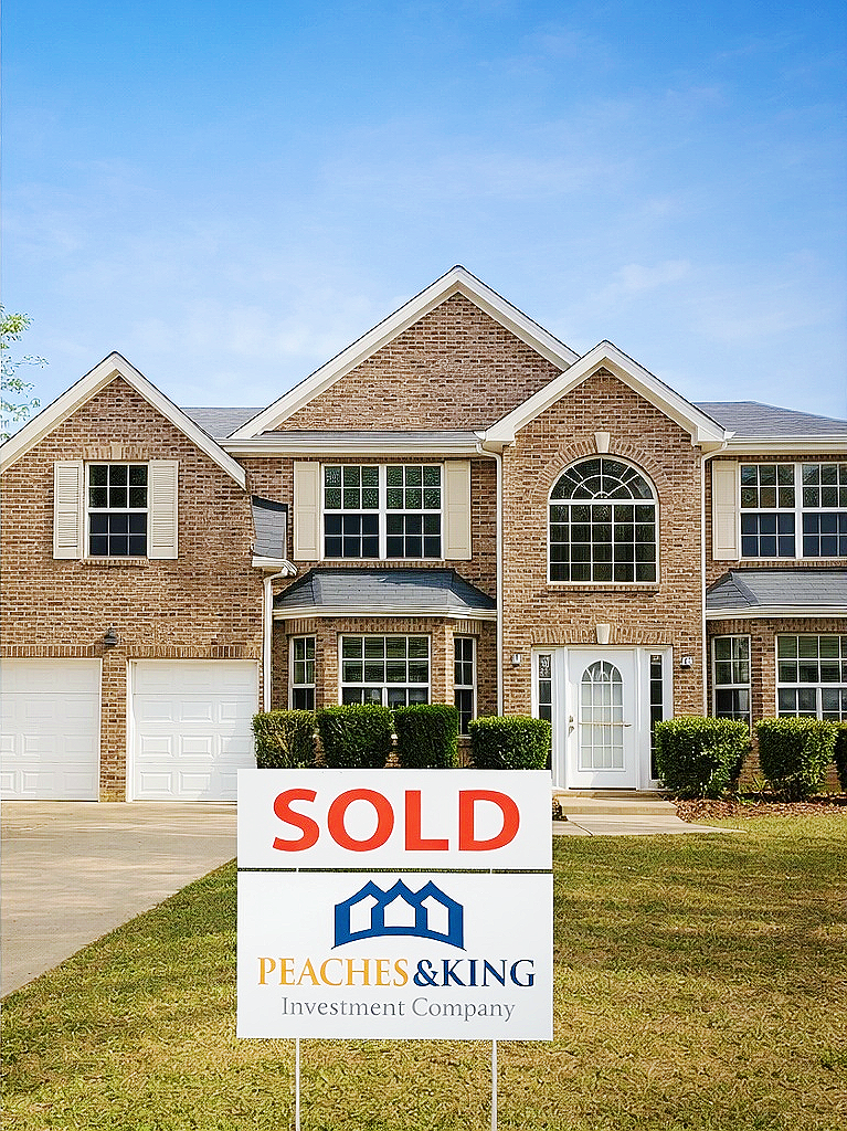 A second brick home showcased by Peaches & King, with the original sold sign.